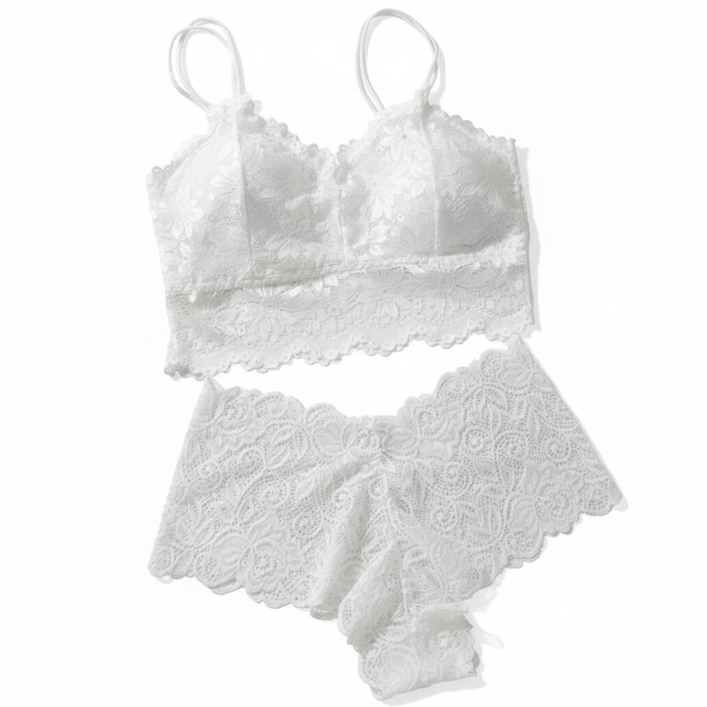White lace lingerie set on a beige surface with a newspaper and candles.