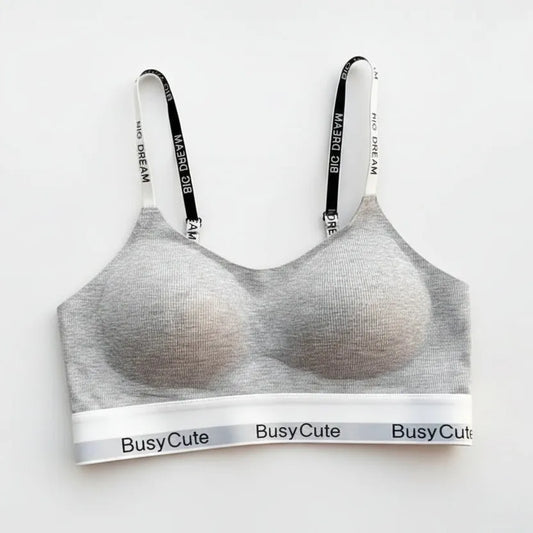 Gray bra with 'BusyCute' branding on a magazine with a blurred cover