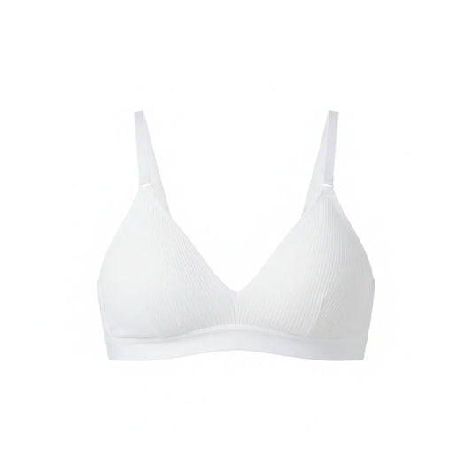 White bra on a wooden hanger with a white cup and saucer in the background