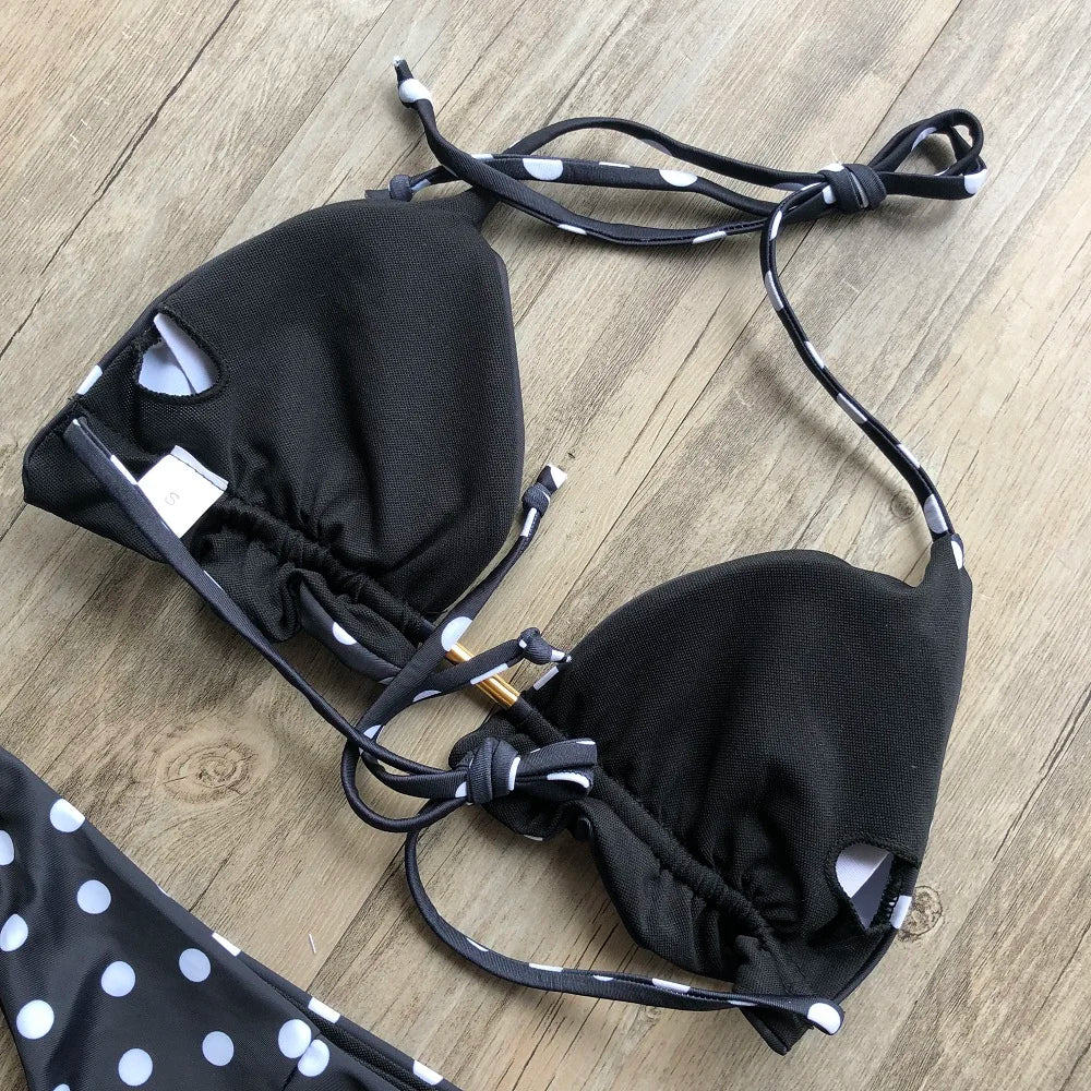 Black bikini with white polka dots on a wooden surface