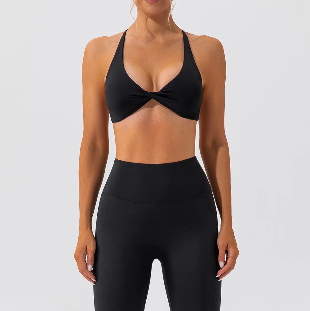 Person wearing a black sports bra and leggings set on a white background