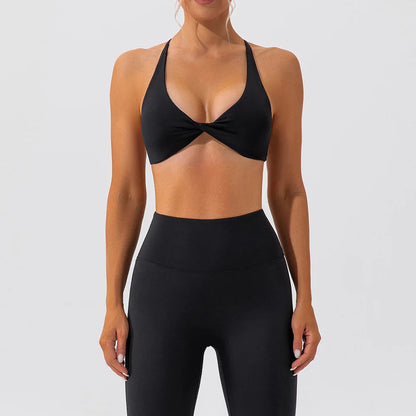 Person wearing a black sports bra and leggings set on a white background