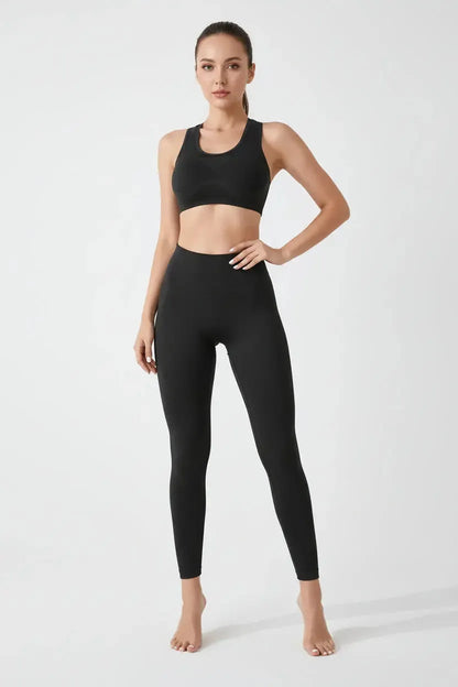Black sports bra worn by a person on a plain background