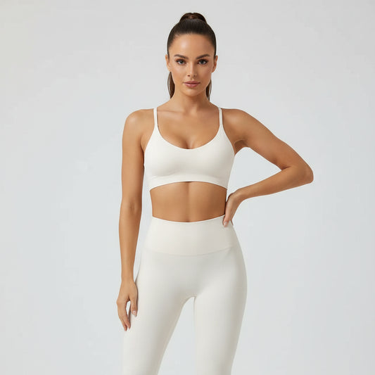 Woman wearing a beige sports bra and leggings against a white background