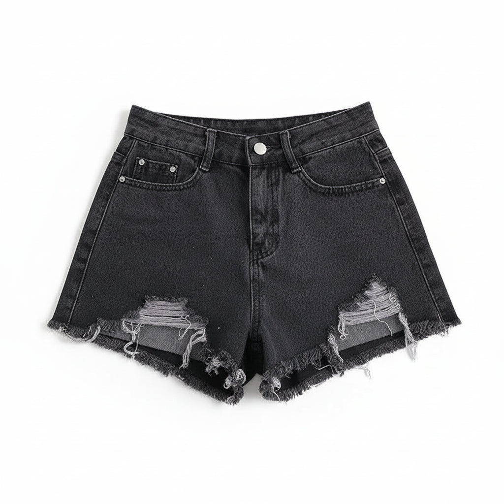 Black denim shorts with frayed edges on a white surface with a magazine.