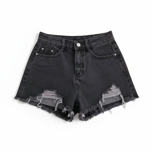 Black denim shorts with frayed edges on a white surface with a magazine.