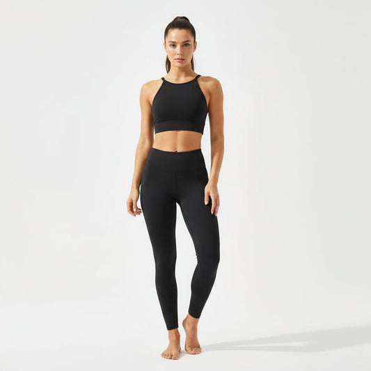 Woman wearing a black sports bra and leggings on a white background