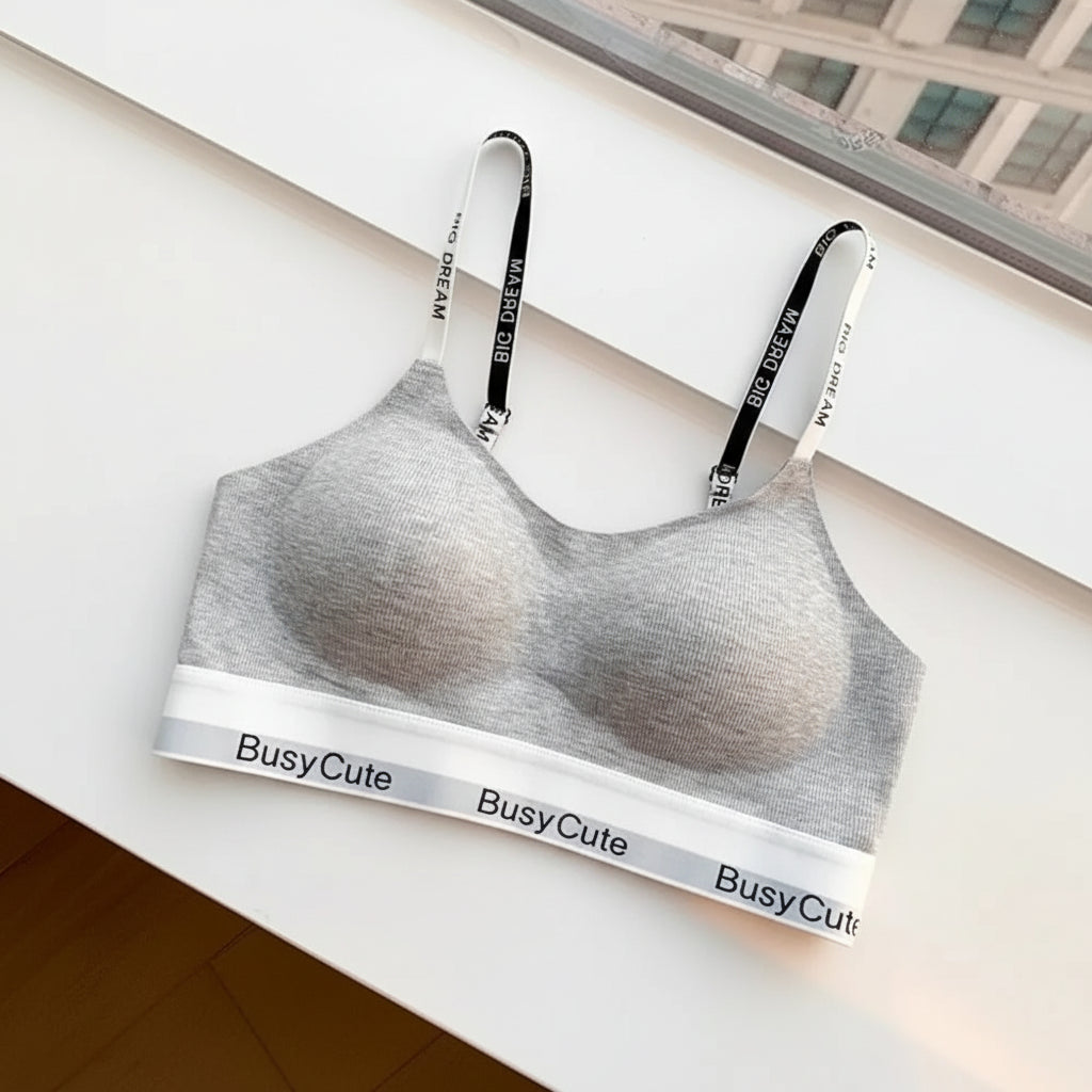 Gray bra with 'BusyCute' branding on a magazine with a blurred cover