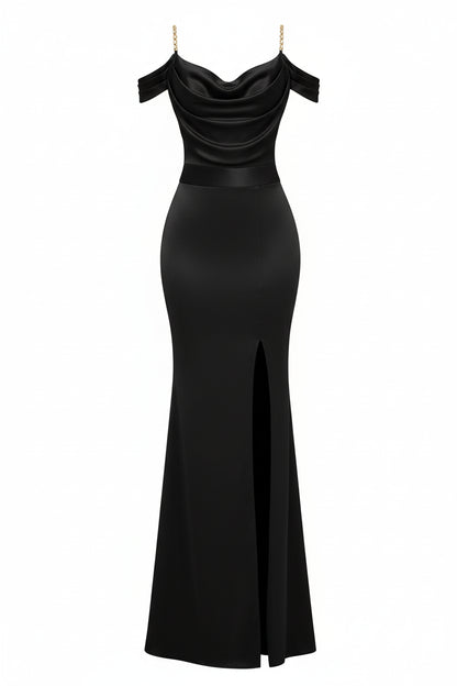 Woman in a black off-shoulder evening gown with a high slit, holding a gold clutch in a bright room.