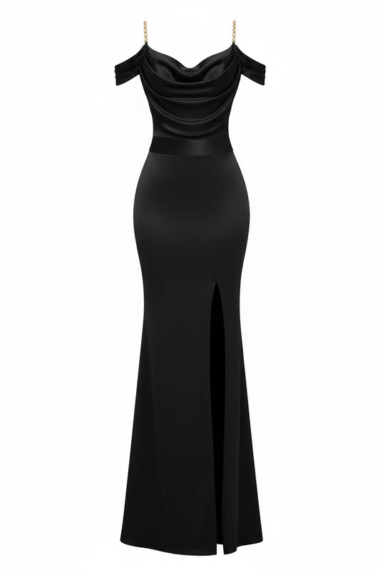 Woman in a black off-shoulder evening gown with a high slit, holding a gold clutch in a bright room.