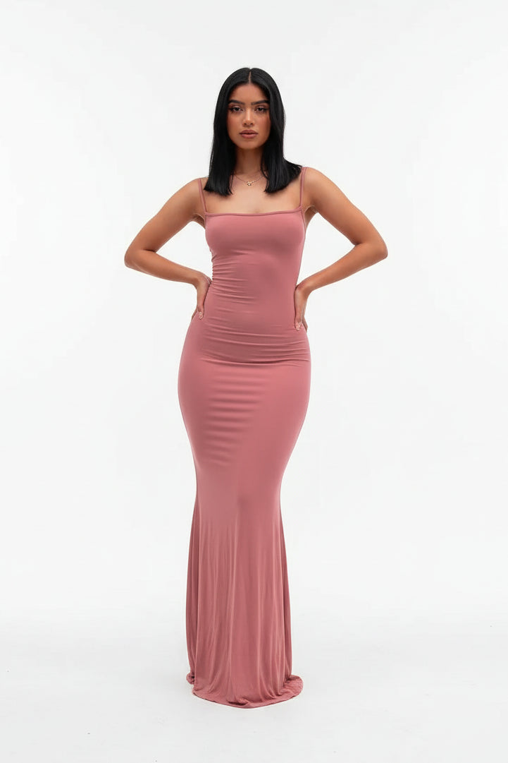 Woman wearing a pink evening gown against a gray background